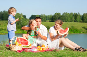 Familie an der Tauber Picknick mit Melone und Seifenblasen