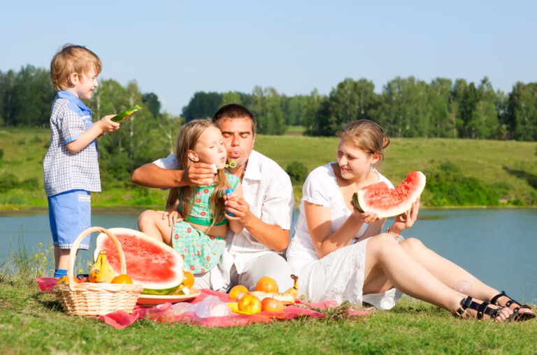 Familie an der Tauber Picknick mit Melone und Seifenblasen