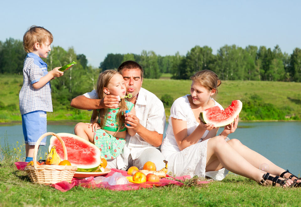 Familie an der Tauber Picknick mit Melone und Seifenblasen