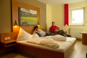 a man and woman sitting on a bed